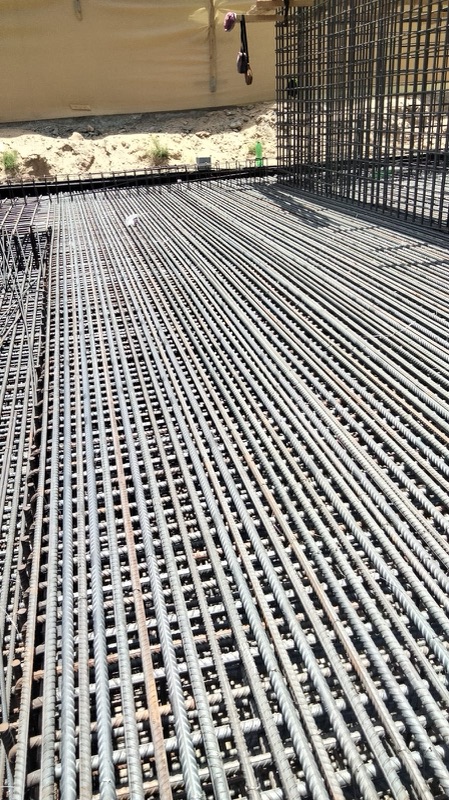 Close view of a fixed raft reinforcement mat with column cages behind